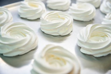 Yumuşak ve yapışkan süt beyaz zefir demir tepside soğuyor. Yuva şeklindeki şekerlemeler gibi. Ev yapımı şeker üretimi.