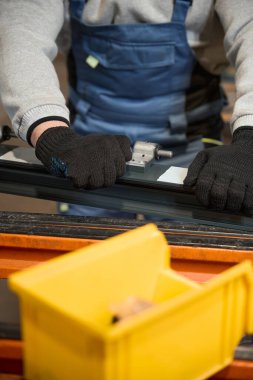 Uzman bir üretim atölyesinde çalışıyor, koruyucu eldiven kullanıyor.