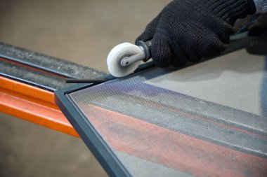 Uzman, sivrisinek ağıyla bir çerçeve yapıyor, özel bir alet kullanıyor.