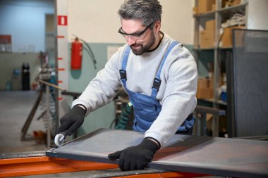 Gülümseyen işçi sivrisinek ağıyla bir çerçeve yapar, özel bir alet kullanır.