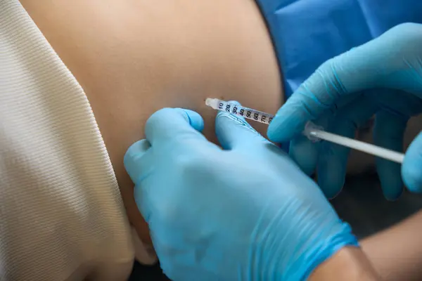 stock image Closeup of dermatosurgeon in nitrile gloves administering subcutaneous injection to adult patient