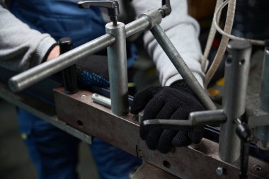 İşçi özel bir makinenin bir parçasını tamir etti. Koruyucu eldiven takan işçi.