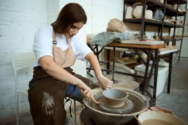 Yaratıcı stüdyodaki çömlekçi masa takımı kalıpçılığı yapan kadın seramist. El işi seramik çömlek üretimi