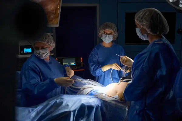 stock image Surgeons performing complex operation to save a person life making an incision on the skin with a scalpel