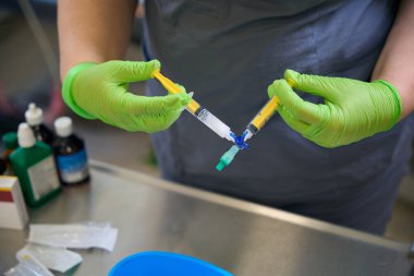 Health worker prepares a syringe with medicine for injection, a disposable syringe is used clipart