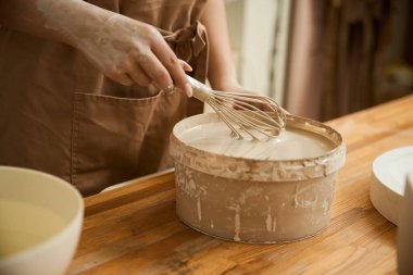 Genç bayan heykeltraşın yakın çekimi sıva atölyesinde çalışıyor. Çömlek oluşturma süreci