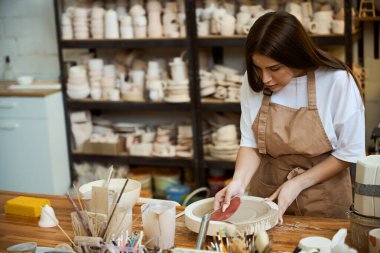 Çömlek atölyesinde çalışan kadın seramik, tabak yapıyor. Çömlek oluşturma süreci