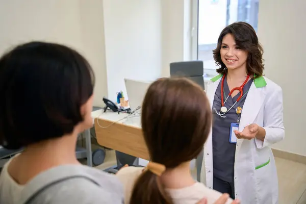 stock image Home doctor greets a teenage girl at a clinic appointment, with the girls mother nearby