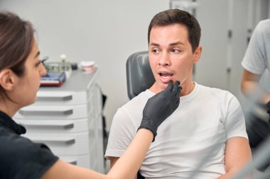 Erkek hasta muayenesi sırasında diş eti iltihabı ve diş minesinin tahrip edildiğini tespit eden dişçi, tedavi yöntemini açıklıyor.