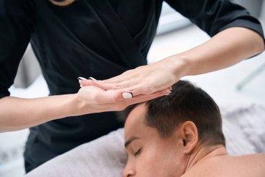 Klinikteki fizyoterapist kadından sırt masajı alırken çekilmiş bir fotoğraf.