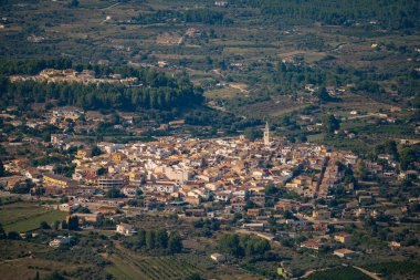 Hava manzarası, tepelik bir arazide yuva yapmış küçük bir kasaba yakalar. Canlı binalar bir araya toplanmış. Parlak gündüz gökyüzünün altında huzurlu ve huzurlu bir atmosfer yaratıyorlar..