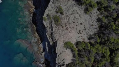 Havadan bakıldığında, Akdeniz 'e bakan yemyeşil ağaçlarla dolu çarpıcı kayalık bir sahil şeridi görülüyor. Huzurlu atmosfer sükuneti ve doğa güzelliğini takdir etmeyi davet eder..