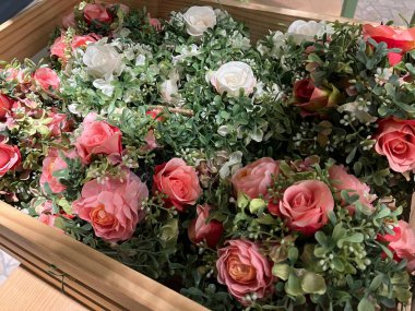 Şirin ve estetik ahşap bir sepetin içindeki plastik çiçek süslemesi. Bu renkli plastik bitkiler genelde odayı tatlandırmak için kullanılır. Yaşayan bir bitki gibi şekli göze çok hoş geliyor..