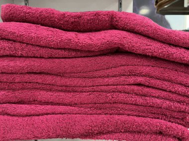 Havlular rafa düzgünce yerleştirilmiş. Renkli havlu ruloları mağazada sergilenmeye hazır. Detay ve yumuşak havlu kumaşının dokusu kullanıldığında çok rahattır. Terfi için havlu katlanır.