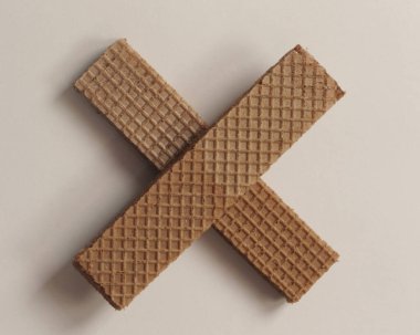 Beyaz ve ahşap arka planda çikolata aromalı kremalı gofretler. Çikolatalı Wafer. Çikolatalı Pipet. Farklı şekillerde lezzetli, çıtır çıtır gofretler. Uzun, kare, lezzetli ve çıtır çıtır..