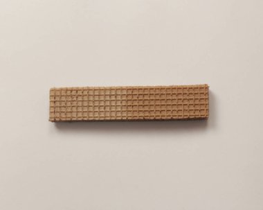 Beyaz ve ahşap arka planda çikolata aromalı kremalı gofretler. Çikolatalı Wafer. Çikolatalı Pipet. Farklı şekillerde lezzetli, çıtır çıtır gofretler. Uzun, kare, lezzetli ve çıtır çıtır..