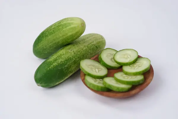 stock image Halves and slices of long cucumber isolated on white background. Green cucumber texture template arranged and harvested. Fresh cucumbers picked from the garden and sold on the shelves in the market.