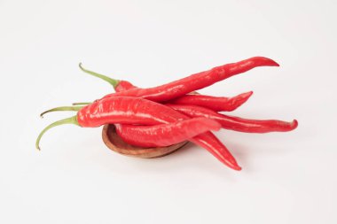 Beyaz arka planda taze kırmızı biber. Dosya kırpma yolları içeriyor. Yakın çekim, kırmızı biber dilimlenmiş, çiğ gıda içeriği kavramı. Kırmızı kırmızı biberler izole edilmiş, seçici odaklanma.