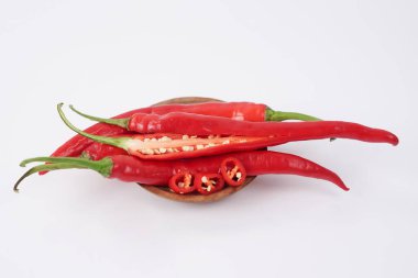 Beyaz arka planda taze kırmızı biber. Dosya kırpma yolları içeriyor. Yakın çekim, kırmızı biber dilimlenmiş, çiğ gıda içeriği kavramı. Kırmızı kırmızı biberler izole edilmiş, seçici odaklanma.