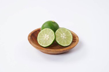 Limonlu meyve. Taze, keskin limonlu, parlak yeşil derili ve sulu bir içi var. Mutfak, sağlıklı ve turunçgiller için ideal. Beyaz arka planda dilimlenmiş olgun kireç meyveleri..