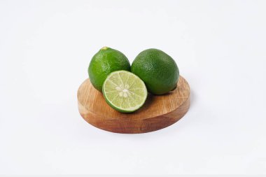 Limonlu meyve. Taze, keskin limonlu, parlak yeşil derili ve sulu bir içi var. Mutfak, sağlıklı ve turunçgiller için ideal. Beyaz arka planda dilimlenmiş olgun kireç meyveleri..