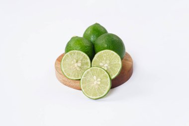 Limonlu meyve. Taze, keskin limonlu, parlak yeşil derili ve sulu bir içi var. Mutfak, sağlıklı ve turunçgiller için ideal. Beyaz arka planda dilimlenmiş olgun kireç meyveleri..