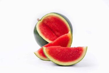 Tam karpuz ve tohum dilimleri beyaz arka planda önden ve üstten görülüyor. Karpuz dilimleri kırmızı, köhne ve suludur..