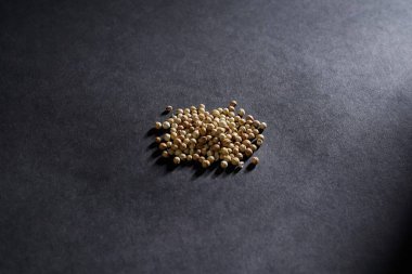 Kişniş tohumu koyu arkaplan, baharat konsepti, kurutulmuş kişniş tohumlarının yakın plan dokusu