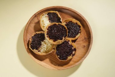 Martabak mini veya terang bulan mini, un, yumurta, maya, peynir veya çikolatayla kaplanmış Endonezya 'nın popüler sokak yemeklerinden biridir. Sarı arka planda izole edilmiş küçük tatlı martabak..