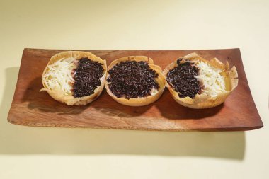 Martabak mini veya terang bulan mini, un, yumurta, maya, peynir veya çikolatayla kaplanmış Endonezya 'nın popüler sokak yemeklerinden biridir. Sarı arka planda izole edilmiş küçük tatlı martabak..