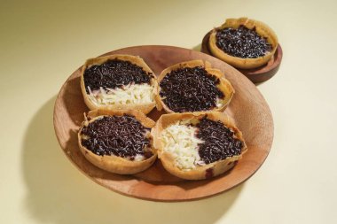 Martabak mini veya terang bulan mini, un, yumurta, maya, peynir veya çikolatayla kaplanmış Endonezya 'nın popüler sokak yemeklerinden biridir. Sarı arka planda izole edilmiş küçük tatlı martabak..
