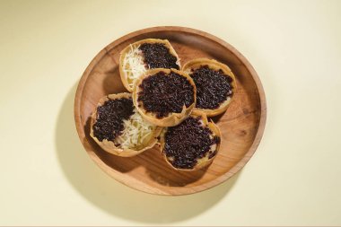 Martabak mini veya terang bulan mini, un, yumurta, maya, peynir veya çikolatayla kaplanmış Endonezya 'nın popüler sokak yemeklerinden biridir. Sarı arka planda izole edilmiş küçük tatlı martabak..