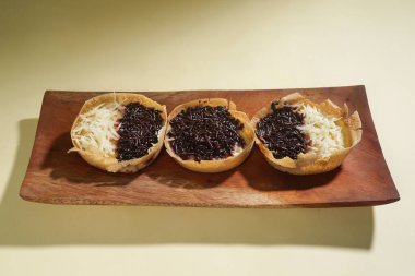 Martabak mini veya terang bulan mini, un, yumurta, maya, peynir veya çikolatayla kaplanmış Endonezya 'nın popüler sokak yemeklerinden biridir. Sarı arka planda izole edilmiş küçük tatlı martabak..