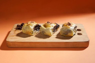 Muz boleni muz ve hamur kabuğundan yapılır ve çikolata ve peynir dolgusu vardır. Tahta tabakta servis ediliyor. Seçici odak resmi.