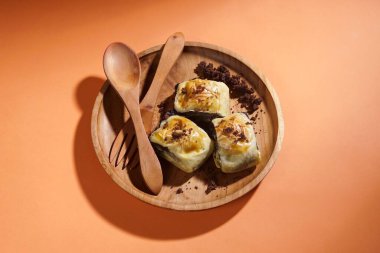 Muz boleni muz ve hamur kabuğundan yapılır ve çikolata ve peynir dolgusu vardır. Tahta tabakta servis ediliyor. Seçici odak resmi.