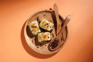 Banana bolen is made from banana and pastry skin and has chocolate and cheese filling. Served in wooden plate. Selective focus image. clipart