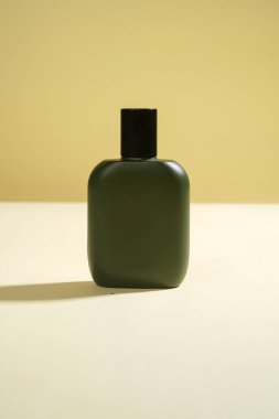 Sarı arka planda siyah spreyli parfüm şişesi. Yüksek çözünürlüklü fotoğraf.               