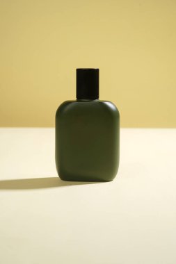 Sarı arka planda siyah spreyli parfüm şişesi. Yüksek çözünürlüklü fotoğraf.               