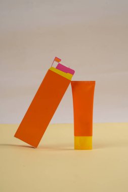 Beyaz ve sarı arkaplanda izole edilmiş güneş kremi tüpü. Vücut bakımı güzellik tedavi konsepti