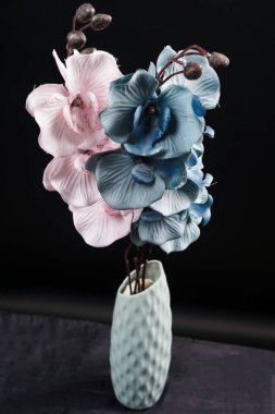 Siyah arka plandaki vazoda pembe ve gri bahar çiçekleri. Yüksek çözünürlüklü. Seçici odak.