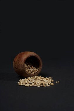 Siyah arka planda izole edilmiş ahşap kasede beyaz peper. Yüksek çözünürlüklü fotoğraf.