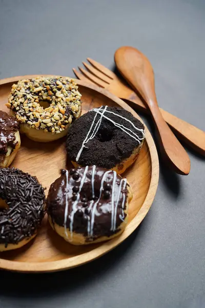 Ahşap tabakta farklı malzemelerle servis edilen çörekler, siyah arka planda üst manzara. Yüksek çözünürlüklü fotoğraf.
