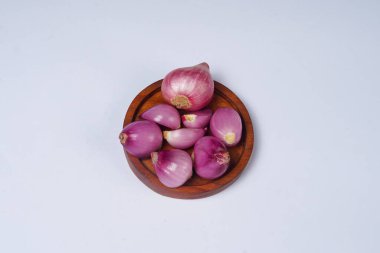 Beyaz arka planda izole edilmiş ahşap kasede kırmızı soğan..