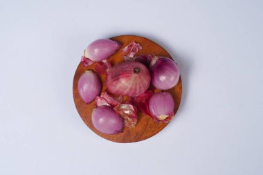 Beyaz arka planda izole edilmiş ahşap kasede kırmızı soğan..