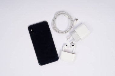 Hızlı şarjlı ve kulaklıklı, beyaz arka planda izole akıllı telefon üst görünümü. Yüksek çözünürlüklü fotoğraf.