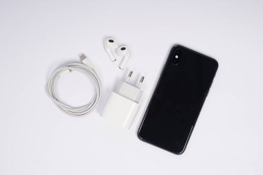 Hızlı şarjlı ve kulaklıklı, beyaz arka planda izole akıllı telefon üst görünümü. Yüksek çözünürlüklü fotoğraf.