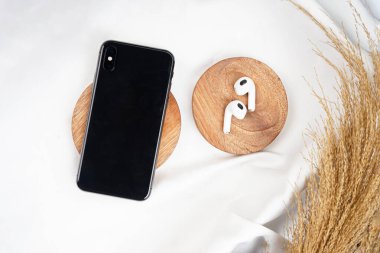 Kulaklığı beyaz arka planda izole edilmiş akıllı telefon üst görüntüsü. Yüksek çözünürlüklü fotoğraf.