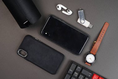 Kulaklığı ve siyah arka planda izole edilmiş lüks saati olan akıllı telefon manzaralı. Yüksek çözünürlüklü fotoğraf.