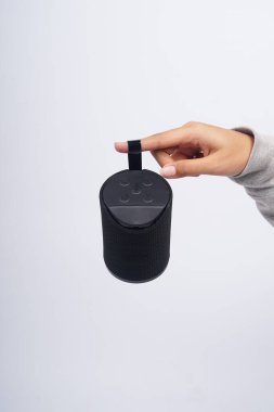 Bluetooth Hoparlörü 'nü tutuyorum. Beyaz arkaplanda ses sistemi olan kablosuz taşınabilir..