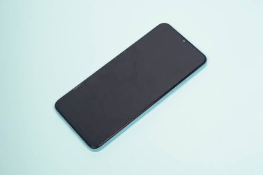 Siyah akıllı telefon mavi arka planda izole edilmiş. Yüksek çözünürlüklü fotoğraf.